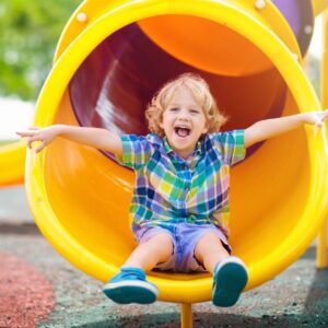 Smiling child at the bottom of a slide