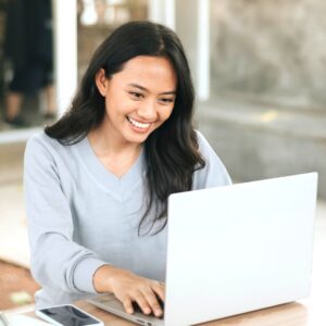 Woman smiling while using a laptop