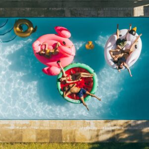 people siting on tubes in pool