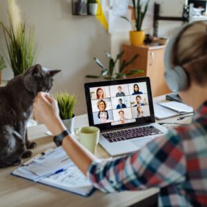 Woman on a group video call petting her cat