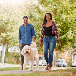Couple walking a dog. 